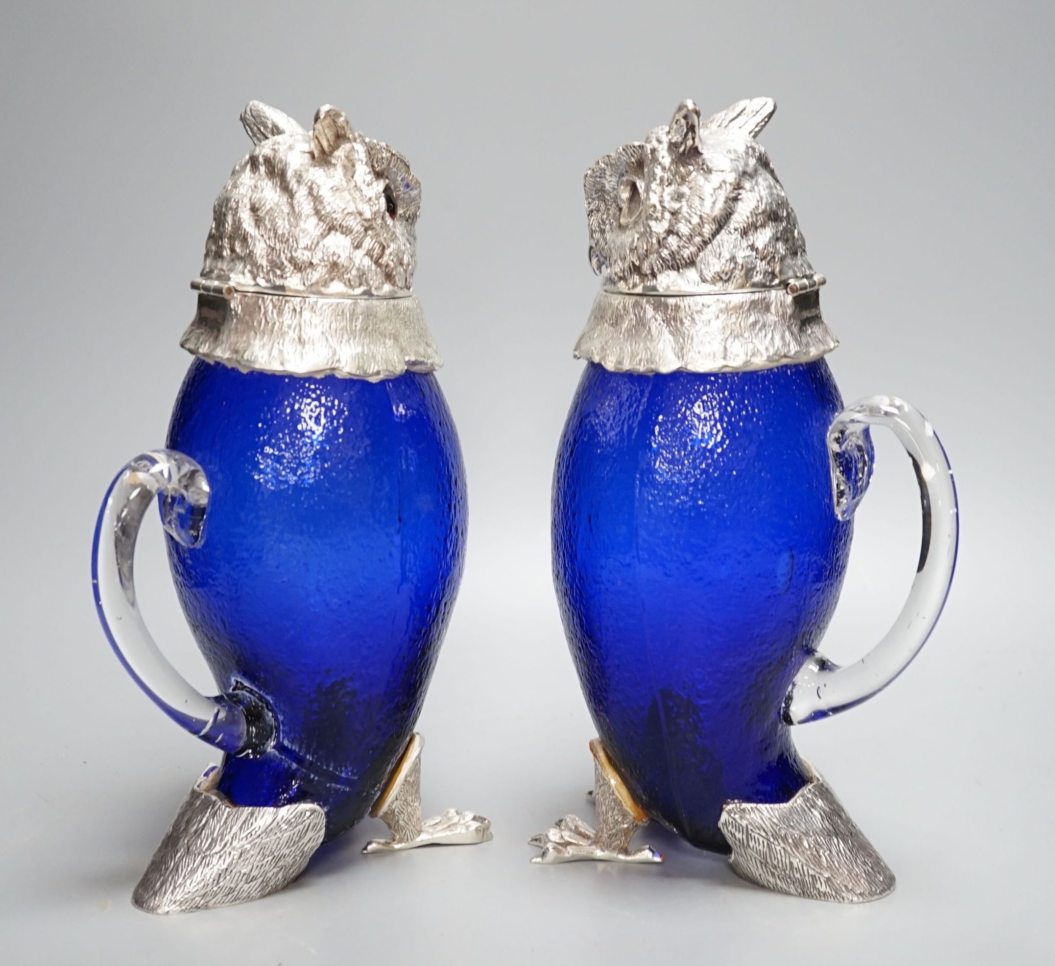 A pair of modern silver plated and blue glass novelty owl flasks, 28.5 cms high.